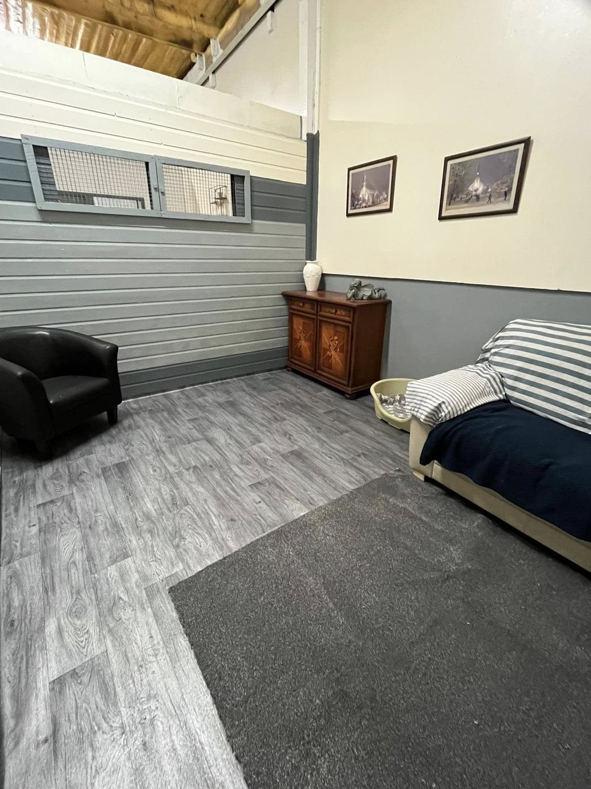 Tresmeer sofa room — navy and white striped sofabed, black leather armchair, pitched ceiling